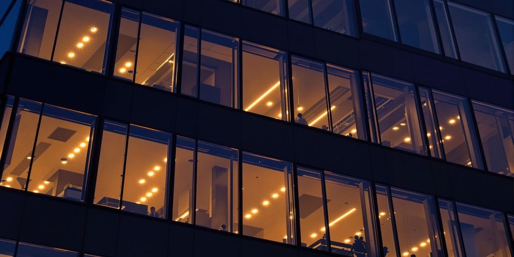 Bâtiment moderne avec des bureaux éclairés, au crépuscule.