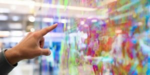 Client interagissant avec un écran tactile dans un magasin.